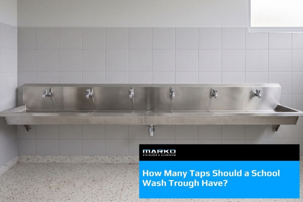 Stainless steel school wash trough with six evenly spaced taps mounted on a tiled amenities wall